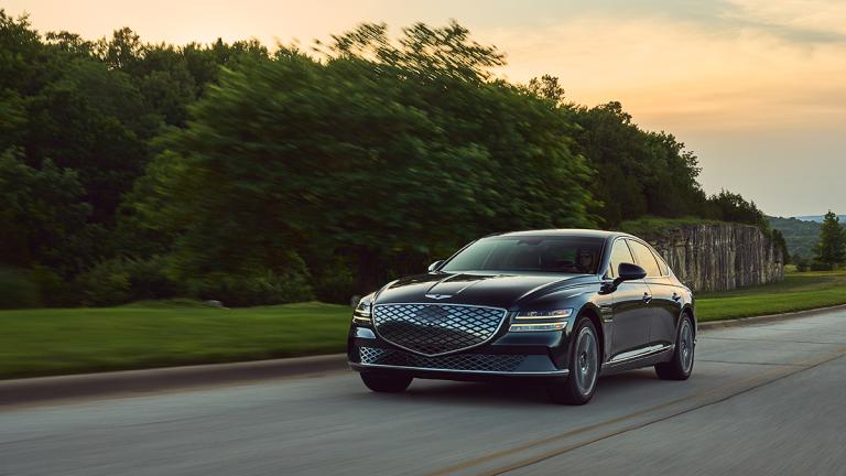 2023 Genesis Electrified G80 surrounded by trees.